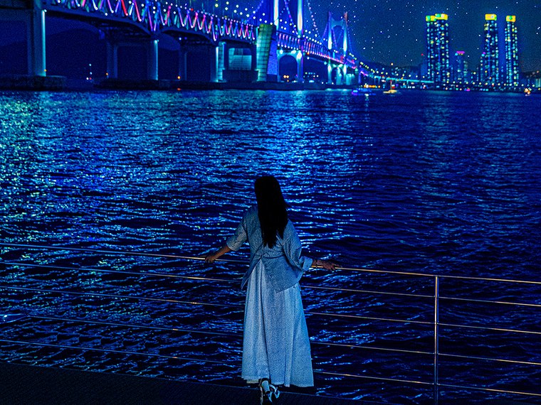 夜の海でドローンショーを見るお客様