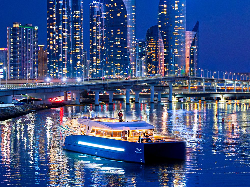マリンシティの夜景前の水営江を進む海雲台リバークルーズ
